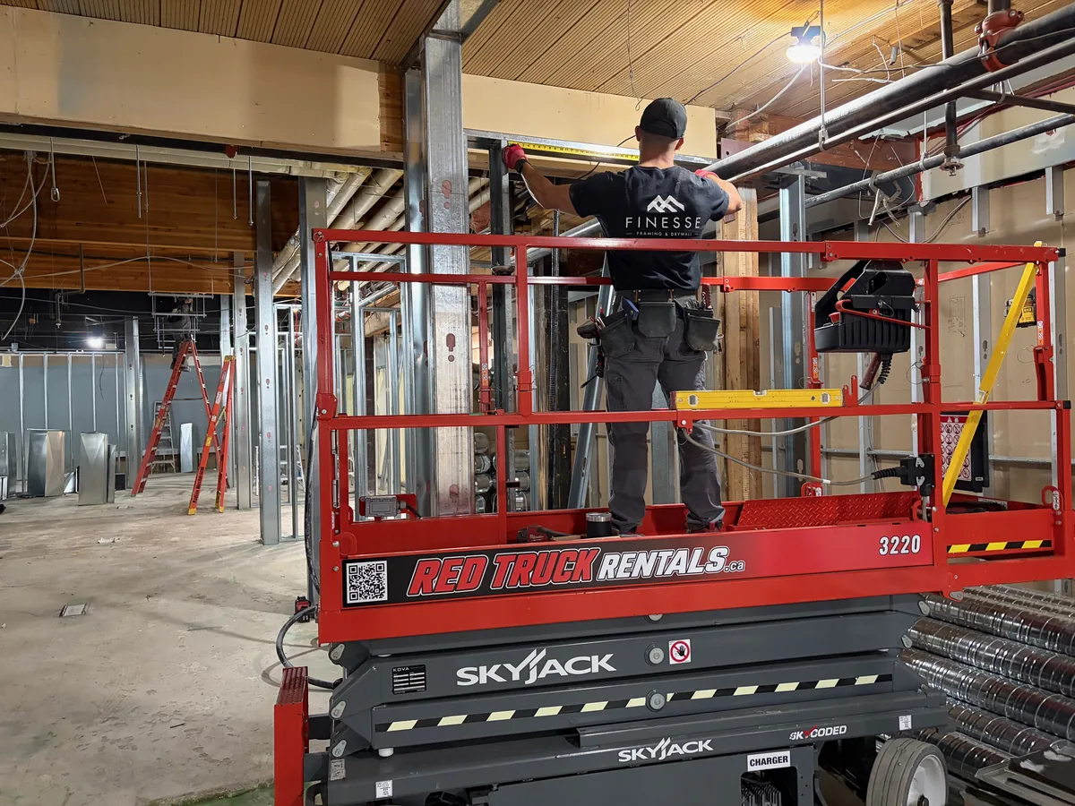 Construction at Bloom Kelowna: a framer working from a scissor lift